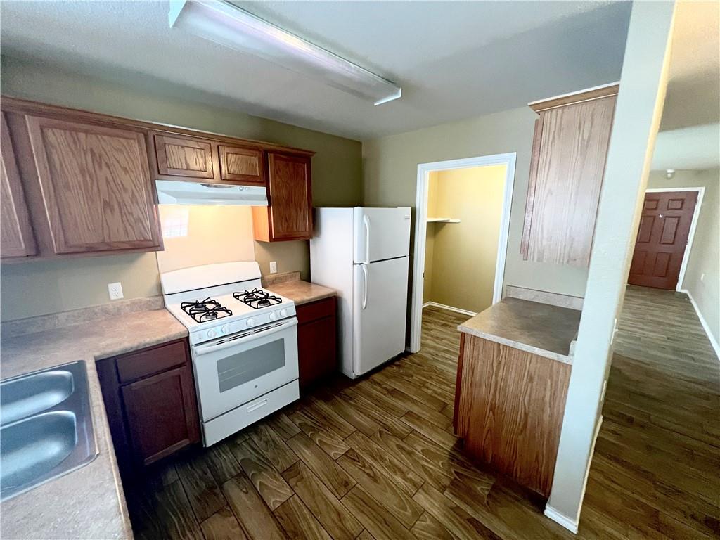 7813 Duber Lane Austin, TX 78747 - Photo 3 of 20 a kitchen with a refrigerator a stove and wooden floor