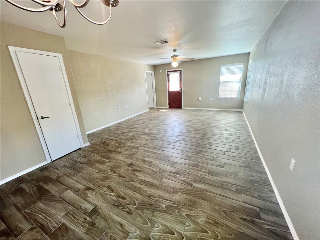 7813 Duber Lane Austin, TX 78747 - Photo 7 of 20 a view of an empty room with wooden floor and a window