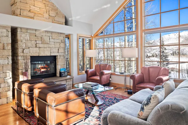a living room with furniture a fireplace and a large window
