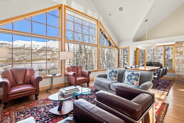 a living room with furniture a rug and a large window