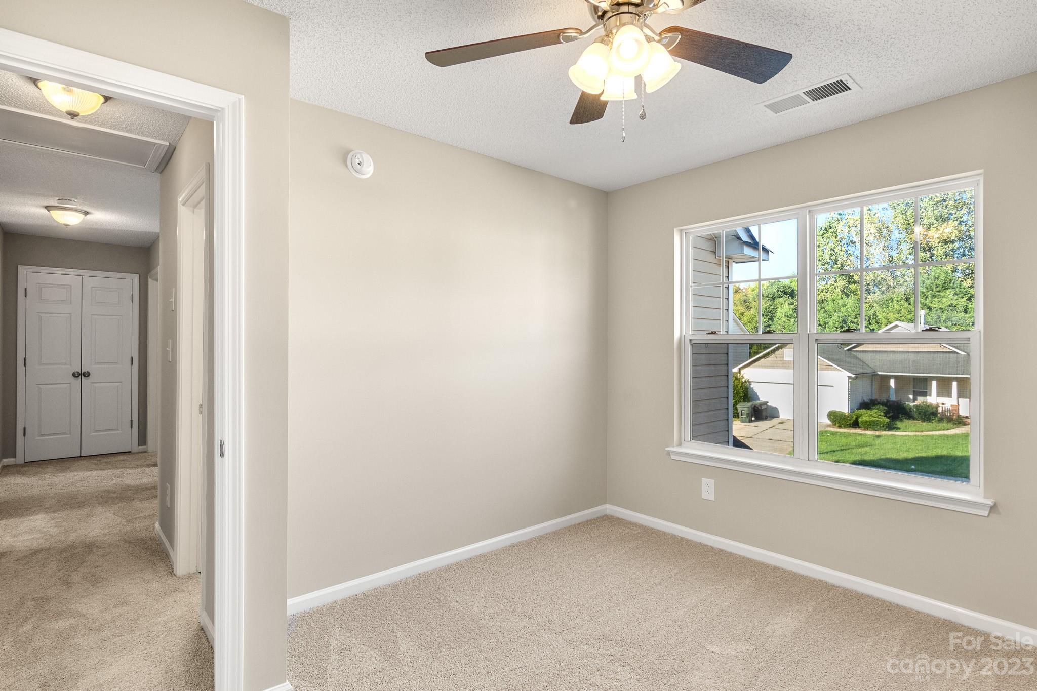 845 Raindrops Road Gastonia, NC 28054 - Photo 34 of 40 an empty room with windows and chandelier fan