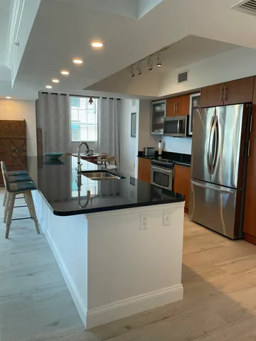 a kitchen with granite countertop a refrigerator and a stove top oven