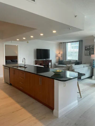 a kitchen with stainless steel appliances granite countertop a table chairs sink and cabinets