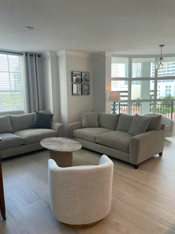 a living room with furniture and a floor to ceiling window