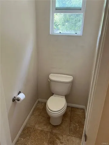 a white toilet sitting next to a window
