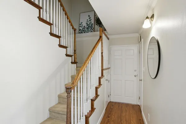 a view of a hallway with wooden floor and entryway