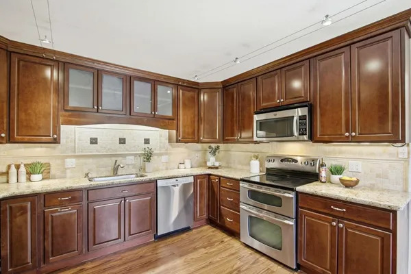 a kitchen with stainless steel appliances granite countertop a sink stove and microwave