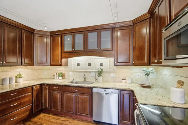 a kitchen with stainless steel appliances granite countertop a sink stove and cabinets