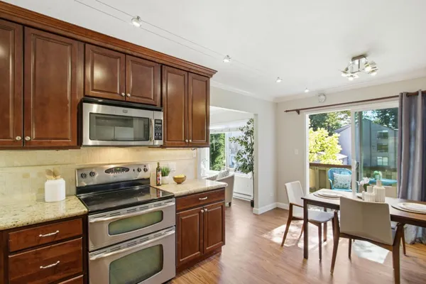 a kitchen with stainless steel appliances granite countertop a stove microwave and cabinets