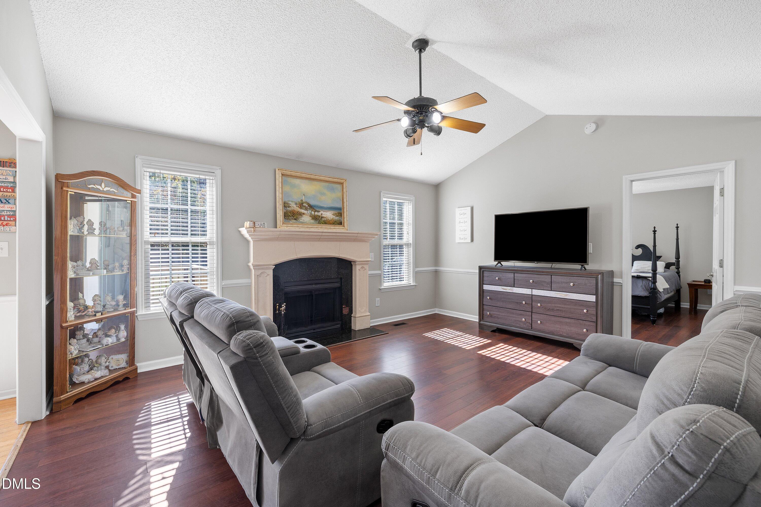 1333 Honeycutt Road Willow Spring, NC 27592 - Photo 8 of 26 a living room with furniture a fireplace and a flat screen tv