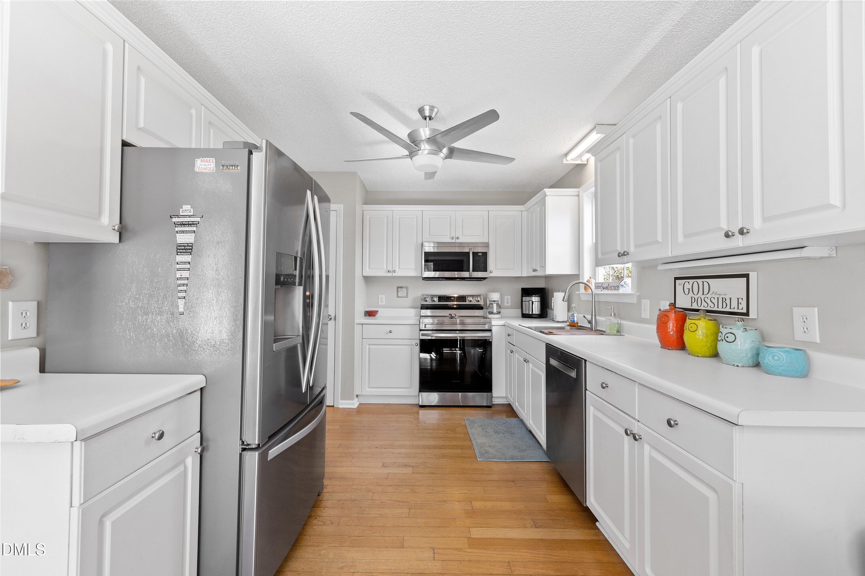 1333 Honeycutt Road Willow Spring, NC 27592 - Photo 10 of 26 a kitchen with stainless steel appliances granite countertop a refrigerator a stove a sink dishwasher and a refrigerator with white cabinets
