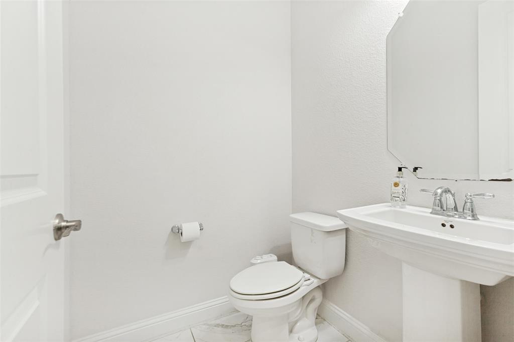 605 Ansley Way Allen, TX 75013 - Photo 24 of 28 Contemporary bathroom featuring a white pedestal sink, chrome faucet, and a wall-mounted mirror