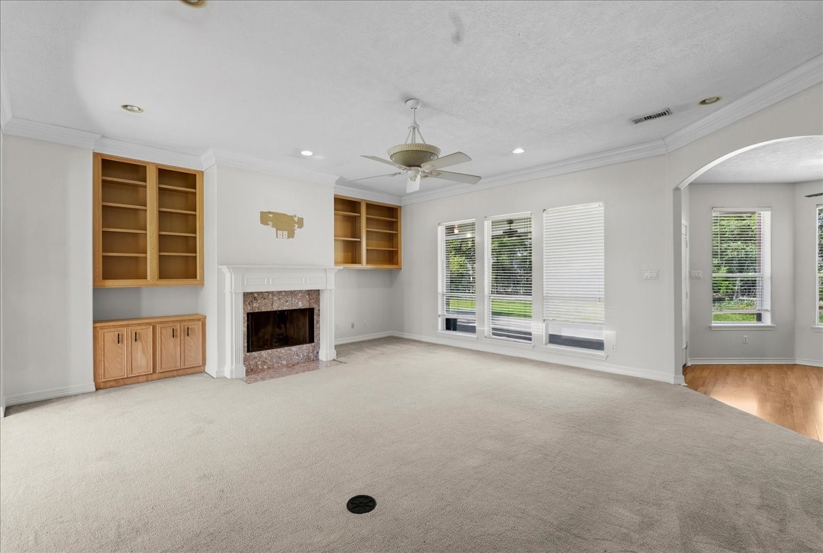 1607 Delta Lane Baytown, TX 77523 - Photo 10 of 48 The living room is spacious and has a fireplace and built ins with large windows looking over the backyard.