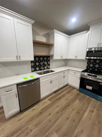 a kitchen with granite countertop a sink a stove and cabinets