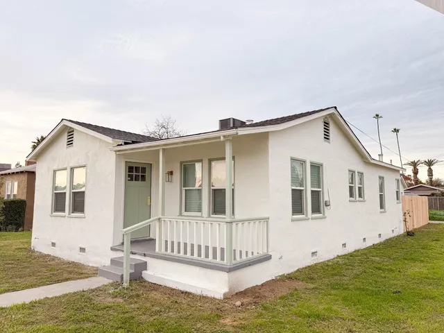 a view of a house with a yard and fence