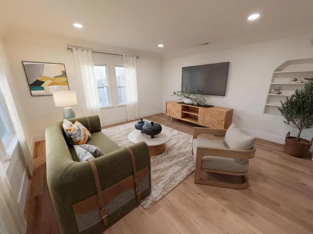 a living room with furniture a flat screen tv and a large window