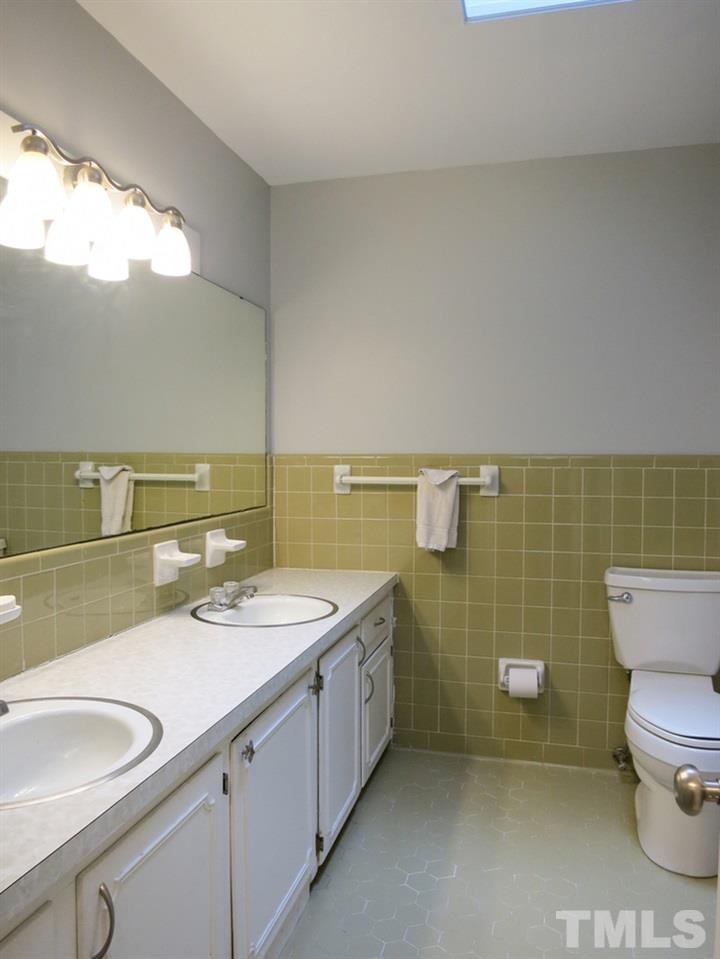 4101 Redington Drive Raleigh, NC 27609 - Photo 22 of 30 The 2 Bedrooms share the big Hall Bath w/tiled flr & walls, tiled tub/shower, linen closet, skylight & long vanity w/double sinks.