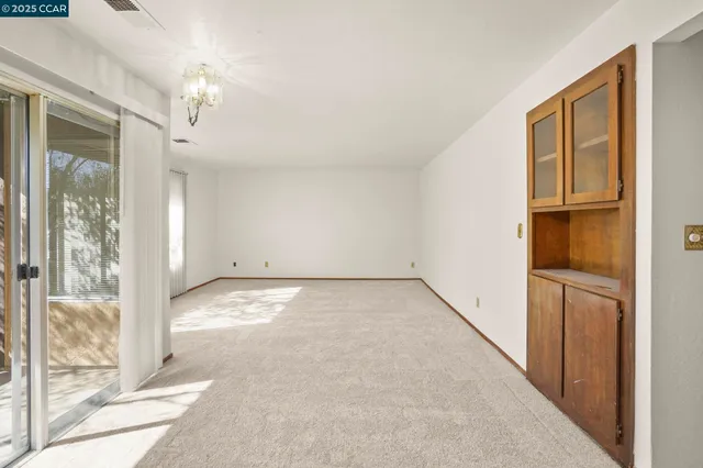a view of a big room with windows and chandelier