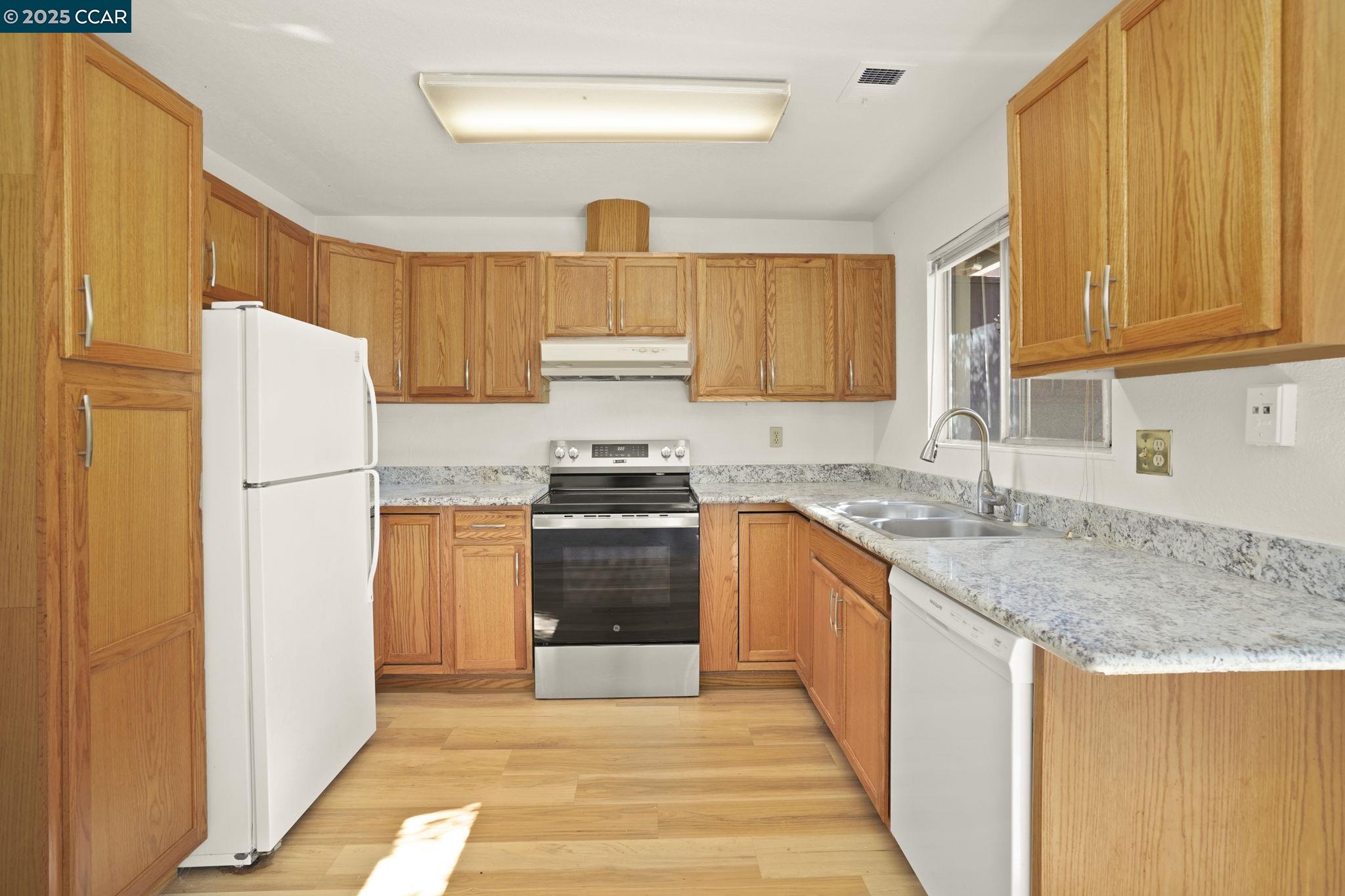 1440 Reganti Place, Unit 11 Concord, CA 94518 - Photo 6 of 15 a kitchen with granite countertop a refrigerator stove top oven and sink