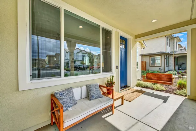 a living room with furniture kitchen view and a wooden floor