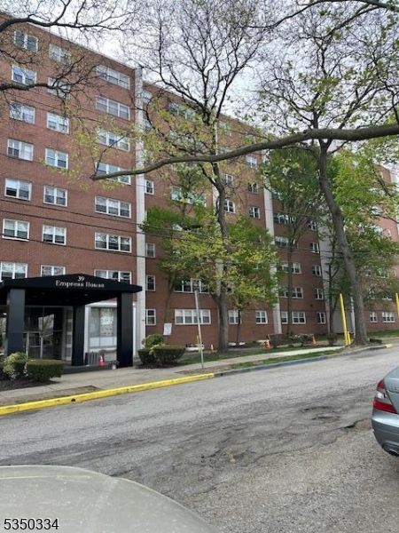 39 East 39th Street, Unit 2L Paterson, NJ 07514 - Photo 1 of 14 a building with trees in front of it