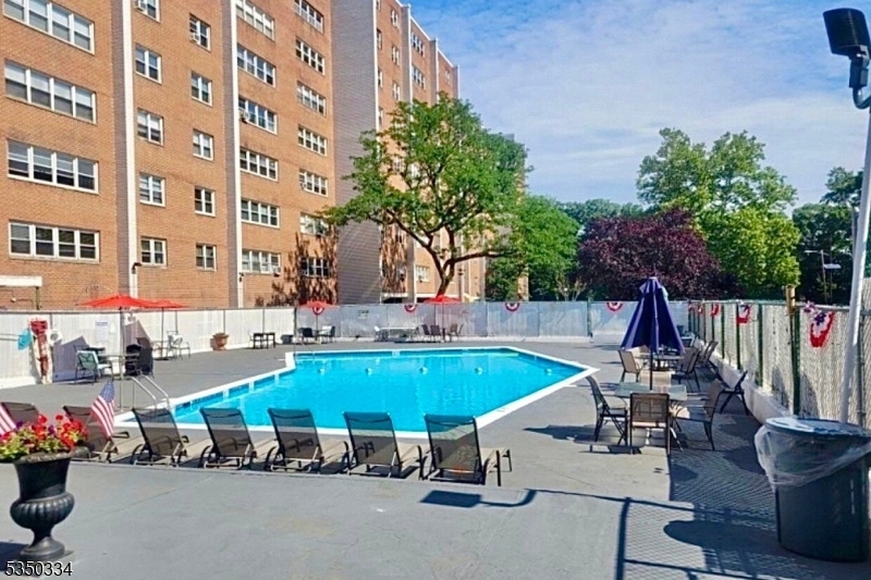 39 East 39th Street, Unit 2L Paterson, NJ 07514 - Photo 12 of 14 a view of a swimming pool with chairs and tables in the patio