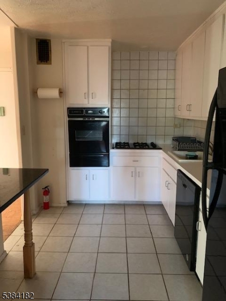 39 East 39th Street, Unit 2L Paterson, NJ 07514 - Photo 3 of 14 a kitchen with a sink a stove and cabinets
