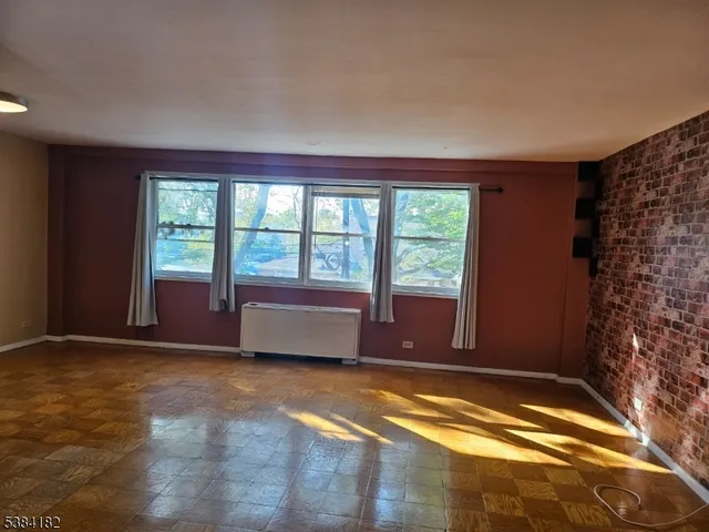 a view of an empty room with a fireplace and a window