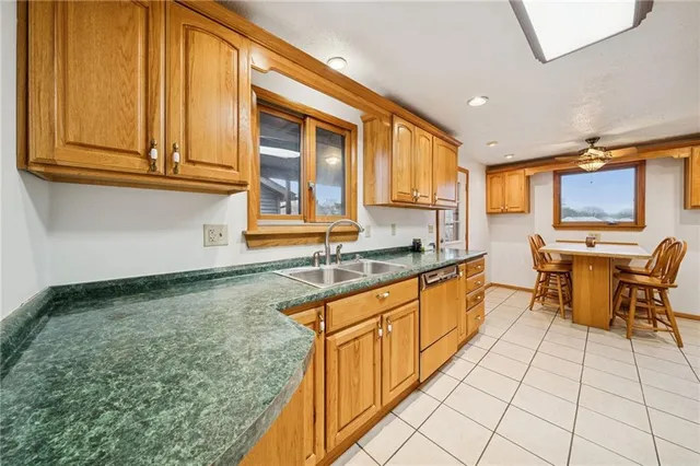 a large kitchen with granite countertop a sink and cabinets