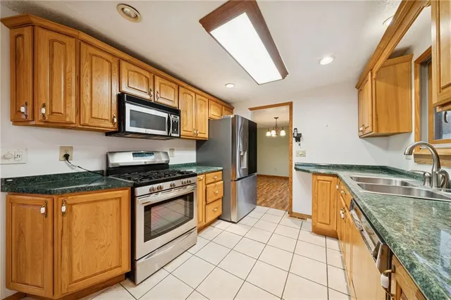 a kitchen with stainless steel appliances granite countertop a stove a sink and a microwave
