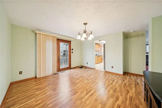 a view of a livingroom with wooden floor and a chandelier