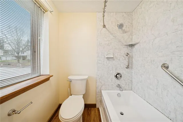 a white toilet sitting next to a bath tub shower