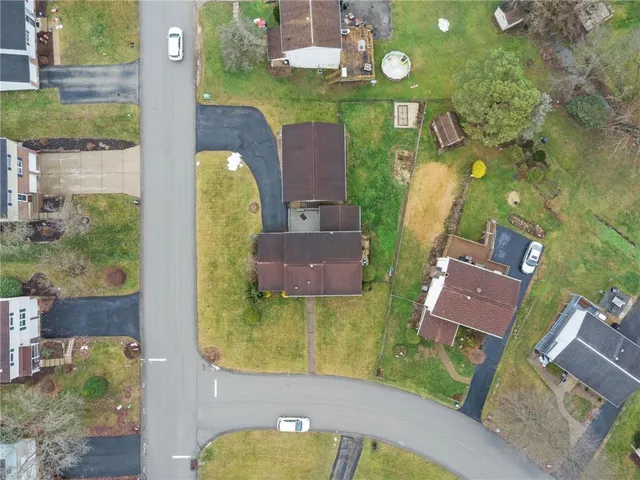 an aerial view of a house with a yard pool and outdoor seating