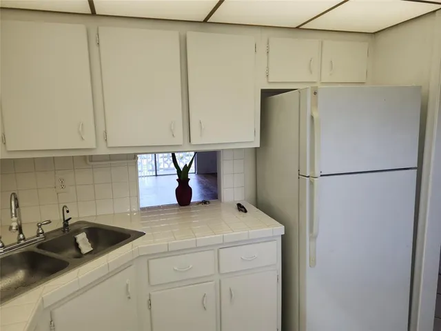 a kitchen with a refrigerator and a sink