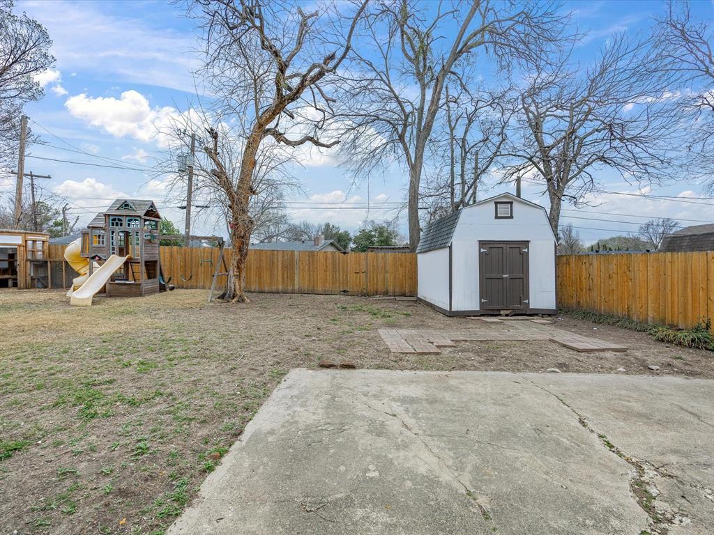 514 West Ridgewood Drive Garland, TX 75041 - Photo 28 of 39 Fenced backyard featuring a shed and a playground