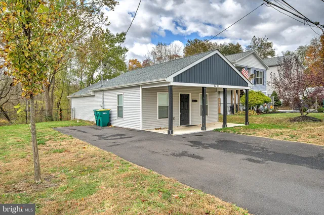 a front view of a house with a garden and trees