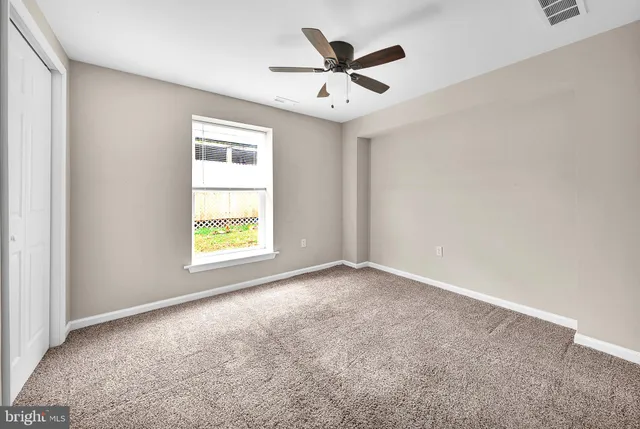 an empty room with chandelier fan