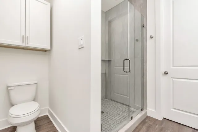 a bathroom with a granite countertop toilet and a shower