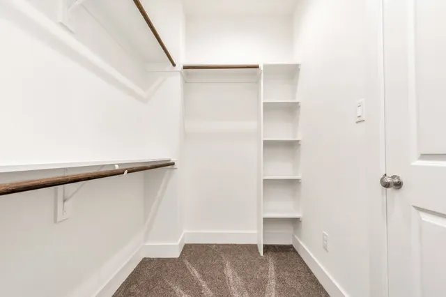 a view of walk in closet with empty racks