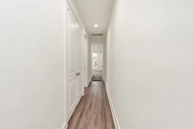 a view of a hallway with wooden floor
