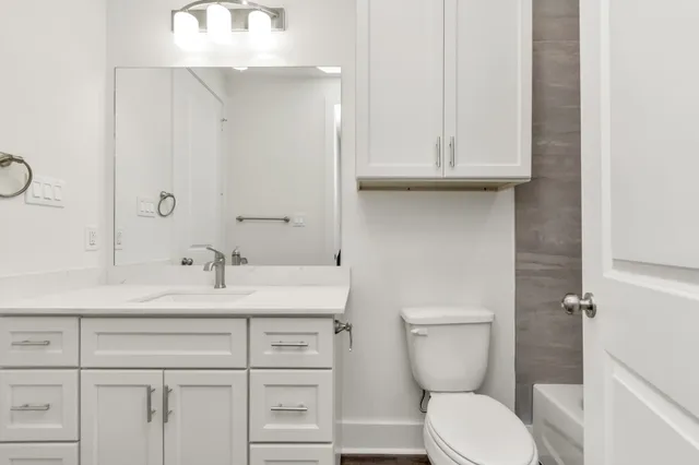 a bathroom with a toilet sink and mirror