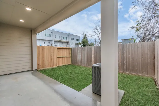 a view of backyard with barbeque grill and wooden fence