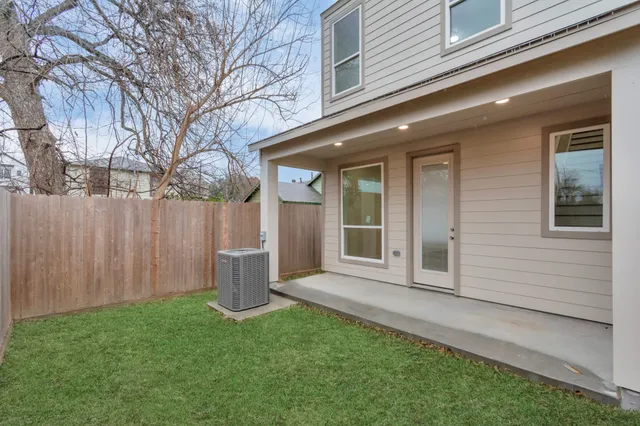 a view of a house with a small yard and a large tree