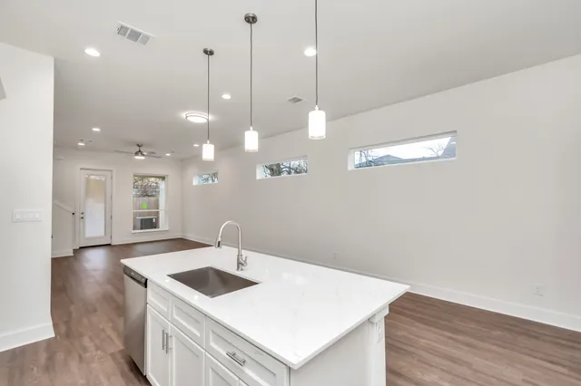 a kitchen with a sink a counter space and wooden floor