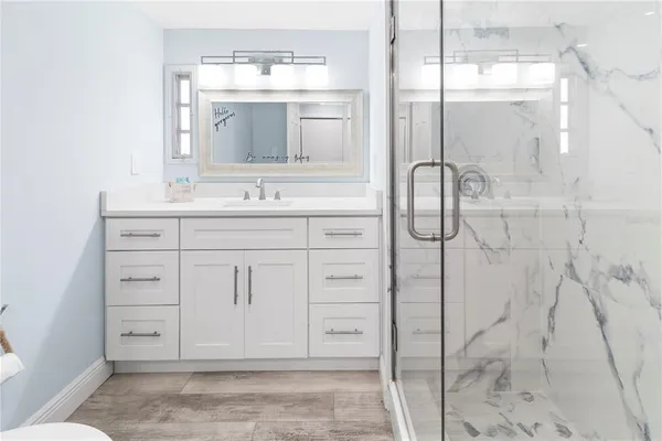 a bathroom with a shower sink and mirror