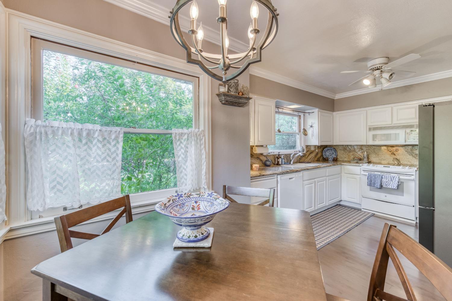 323 East Hampton Way Fresno, CA 93704 - Photo 15 of 44 a kitchen with a table chairs stove and cabinets
