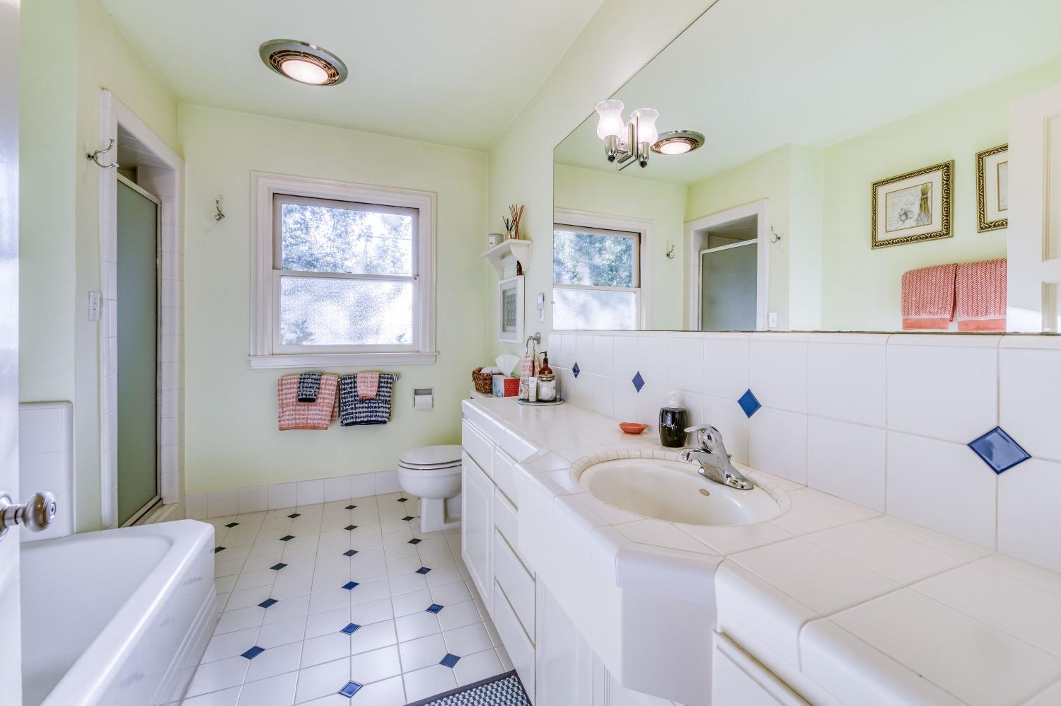 323 East Hampton Way Fresno, CA 93704 - Photo 26 of 44 a bathroom with a sink a mirror and a bathtub