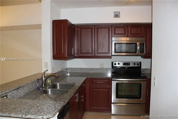 a kitchen with granite countertop a stove and a sink