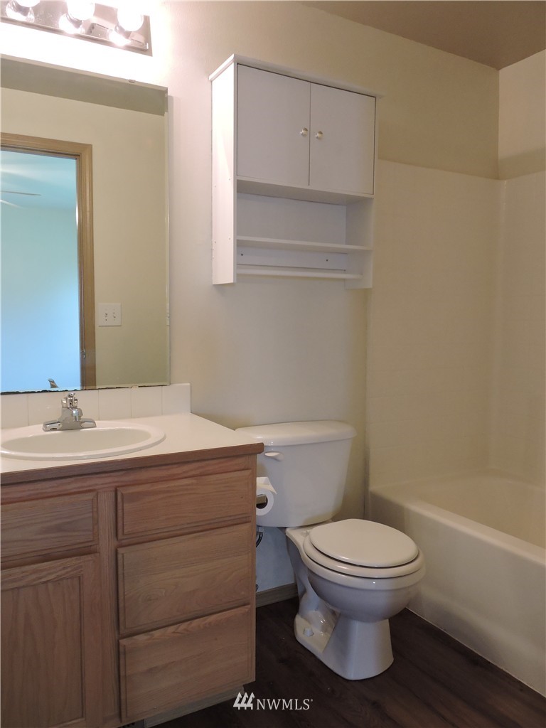 449 Spring Lane Sedro-Woolley, WA 98284 - Photo 6 of 11 a bathroom with a granite countertop toilet a sink and a bathtub