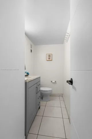 a bathroom with a granite countertop sink a toilet and mirror